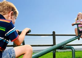 Two kids on a see saw.