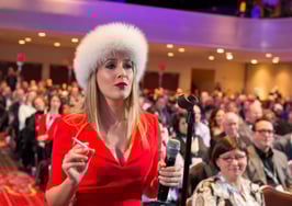 Realtor Cristina Cote in a red dress and furry hat as her alter ego "Svetty."