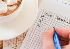 A hand penning New Year's resolutions