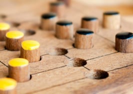 A game board with yellow and black pieces.