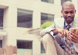 A young black man listening to something on his smartphone.