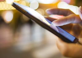 A woman holding an iPhone and using an app.