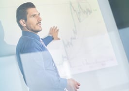 A man making a whiteboard presentation in front of a group