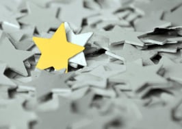 A gold star standing out in a sea of gray stars