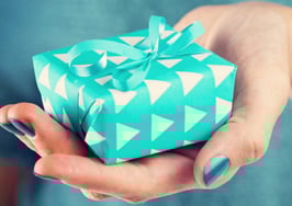 A woman's hand holding out a gift