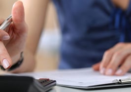 A woman accountant creating a budget using a calculator