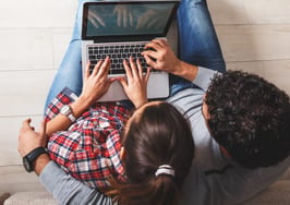 A young couple searching a computer together