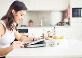 A woman reading her newspaper in the morning