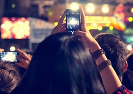 Music festival-goers taking video at a concert