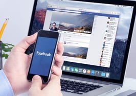 A man checking Facebook on his laptop and his mobile phone