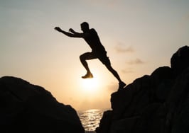 A man jumping across a narrow gap