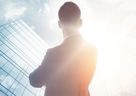 A man in a business suit looking at some buildings