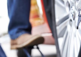 A man pumping up a car tire.
