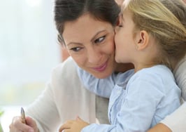 A little girl kissing her mom on the cheek