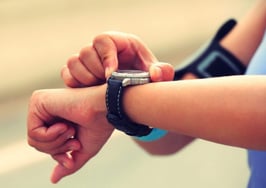 A young woman taking her pulse after a run