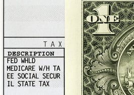 A paycheck stub with a dollar bill