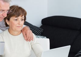 An older couple looking at a computer together