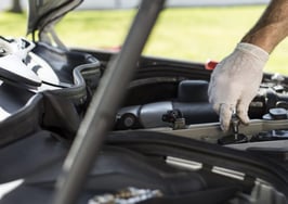 A man giving a car engine a tune-up