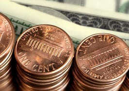 Stacks of pennies near dollar bills