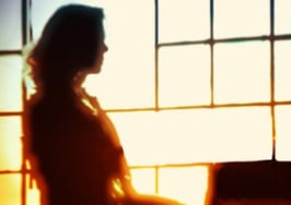 A woman working in a office, backlit by a window