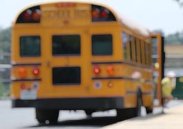 Kids getting off a school bus in blurred focus