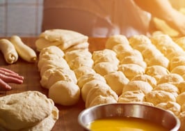 A baker rolling bread made from scratch