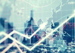 A double-exposure shot of a city and some economic graphs