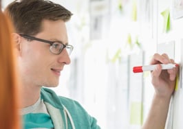 A man taking notes on a board