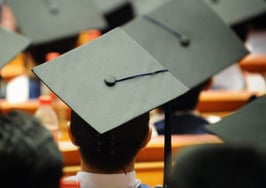 A group of graduation caps listening to a commencement