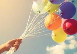 Balloons rising from a child's hand