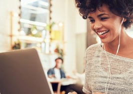 A laughing young woman on her computer