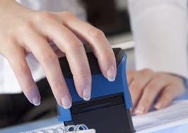 A woman stamping a piece of paper