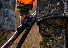 A hunter carrying a rifle