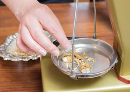A jeweler weighing pieces to value