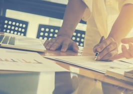 Two people looking at data on a table