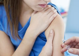 A young girl getting a shot in the arm