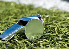 A coach's whistle on grass