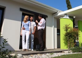 A couple in front of a home with a real estate agent