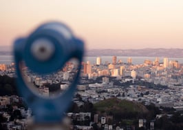 A sky-high view of San Francisco with binoculars in the foreground