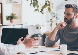 A young man giving advice to a young couple