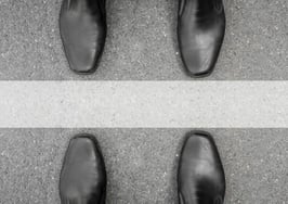 Two men standing on either side of a line on the ground