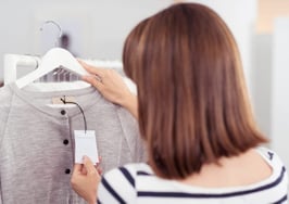 A woman checking a price tag on a shirt