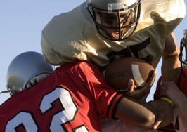 Two defense lineman tackling a quarterback