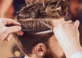 A barber trimming a man's hair
