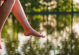A young woman kicking her legs on the end of a pier