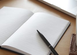 A journal open in front of a computer
