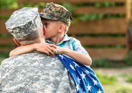 A military father hugging his son