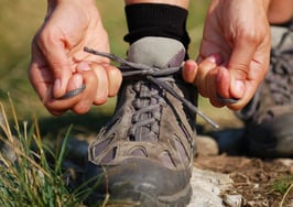 A woman lacing up her hiking boots for the trail