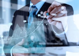 A man charting progress on a graph