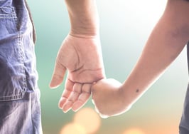 A man holding a child's hand